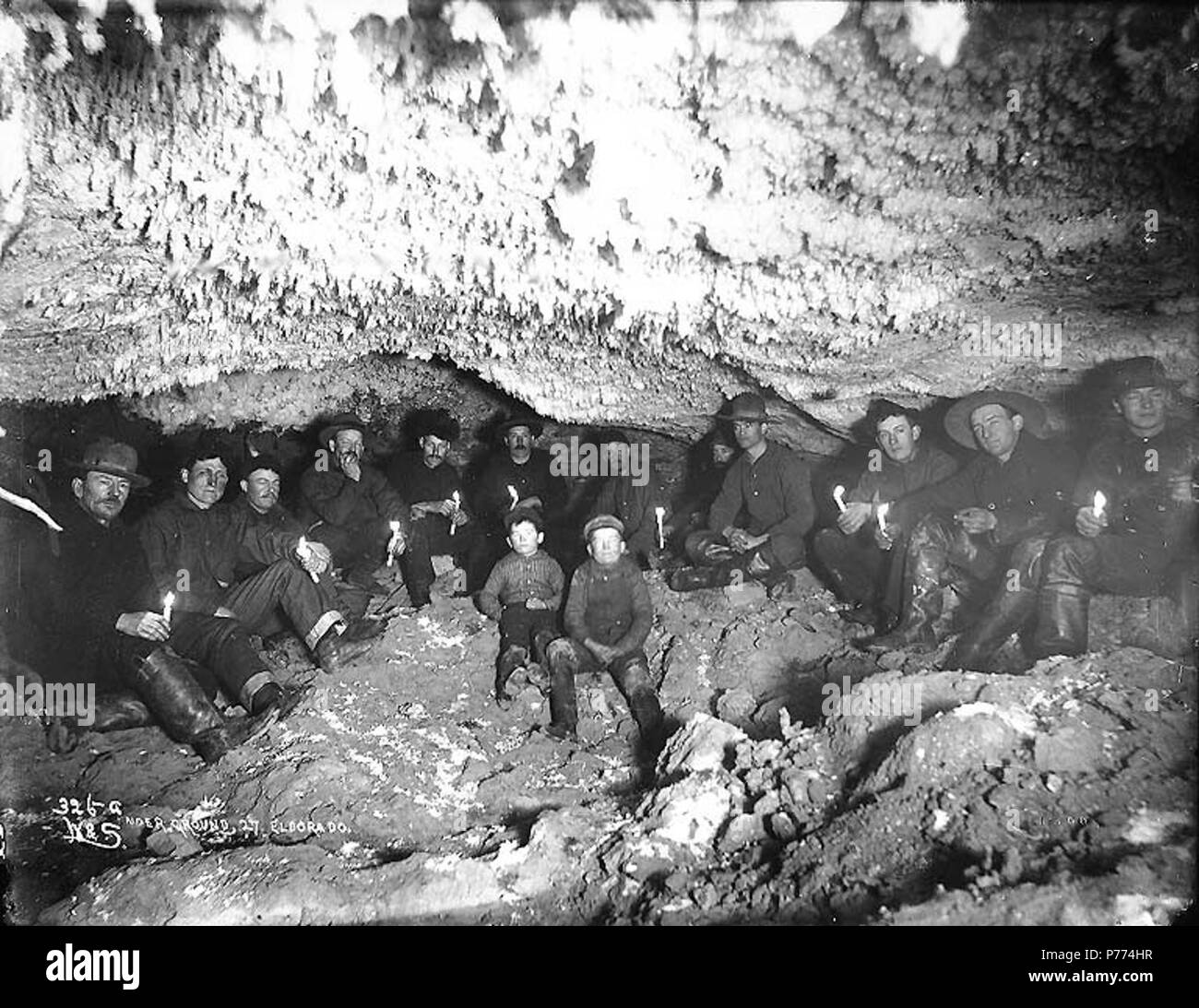 . English: Miners in underground gold mine lit by candlelight, No. 27 Eldorado Creek, Yukon Territory, ca. 1898. English: Caption on image: 'Under ground, 27 Eldorado' Original image in Hegg Album 25, page 19 . Original photograph by Eric A. Hegg 412A; copied by Webster and Stevens 326.A . Klondike Gold Rush. Subjects (LCTGM): Gold miners--Yukon--Eldorado; Gold mining--Yukon--Eldorado; Candles Subjects (LCSH): Yukon--Gold discoveries  . circa 1898 9 Miners in underground gold mine lit by candlelight, No 27 Eldorado Creek, Yukon Territory, ca 1898 (HEGG 8) Stock Photo