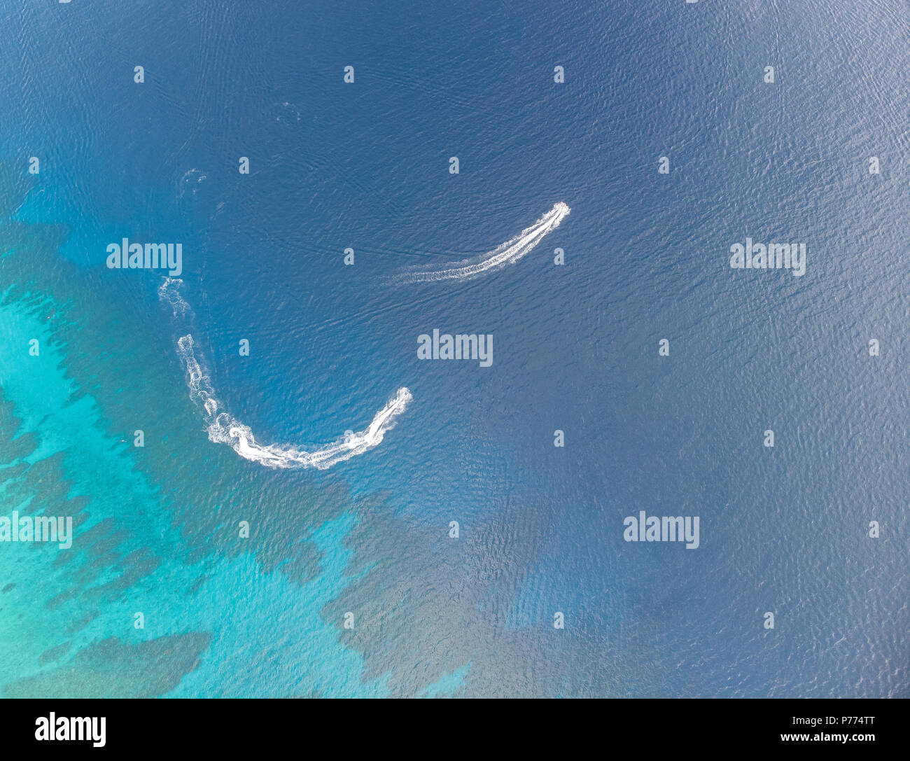 Aerial  overhead view of wave runner by coral reef Stock Photo
