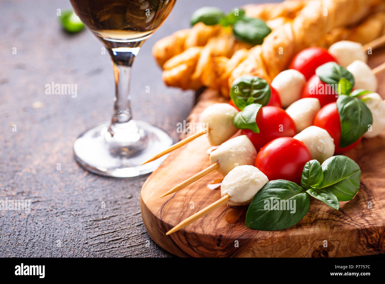 Traditional Italian antipasto caprese skewers and grissini bread Stock