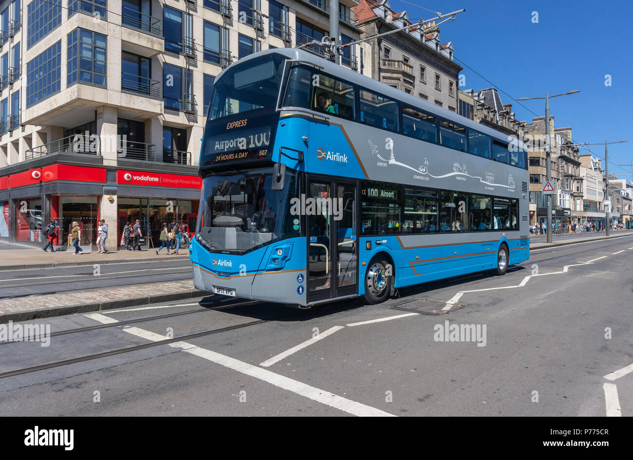 Airlink by Lothian express No 100 heads towards the airport along Princes Street in Edinburgh city Scotland UK Stock Photo