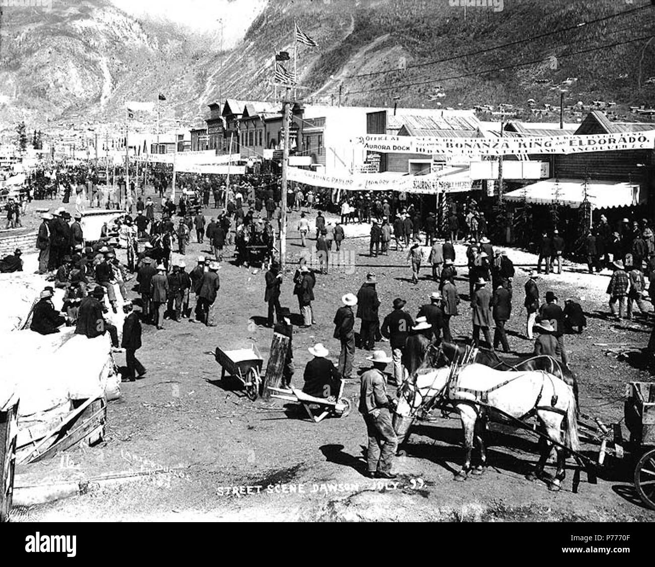 . English: Front Street, Dawson, Yukon Territory, July 1899. English: Shows crowded street scene with advertising banners strung across the street . Caption on image: 'Street scene Dawson July 99' Original photograph by Eric A. Hegg 2333; copied by Larss and Duclos No. 16 appears in the lower left corner . See Hegg 431 for similar view. Klondike Gold Rush. Subjects (LCTGM): Streets--Yukon--Dawson; Advertisements--Yukon--Dawson; Business districts--Yukon--Dawson Subjects (LCSH): Front Street (Dawson, Yukon)  . 1899 5 Front Street, Dawson, Yukon Territory, July 1899 (HEGG 669) Stock Photo