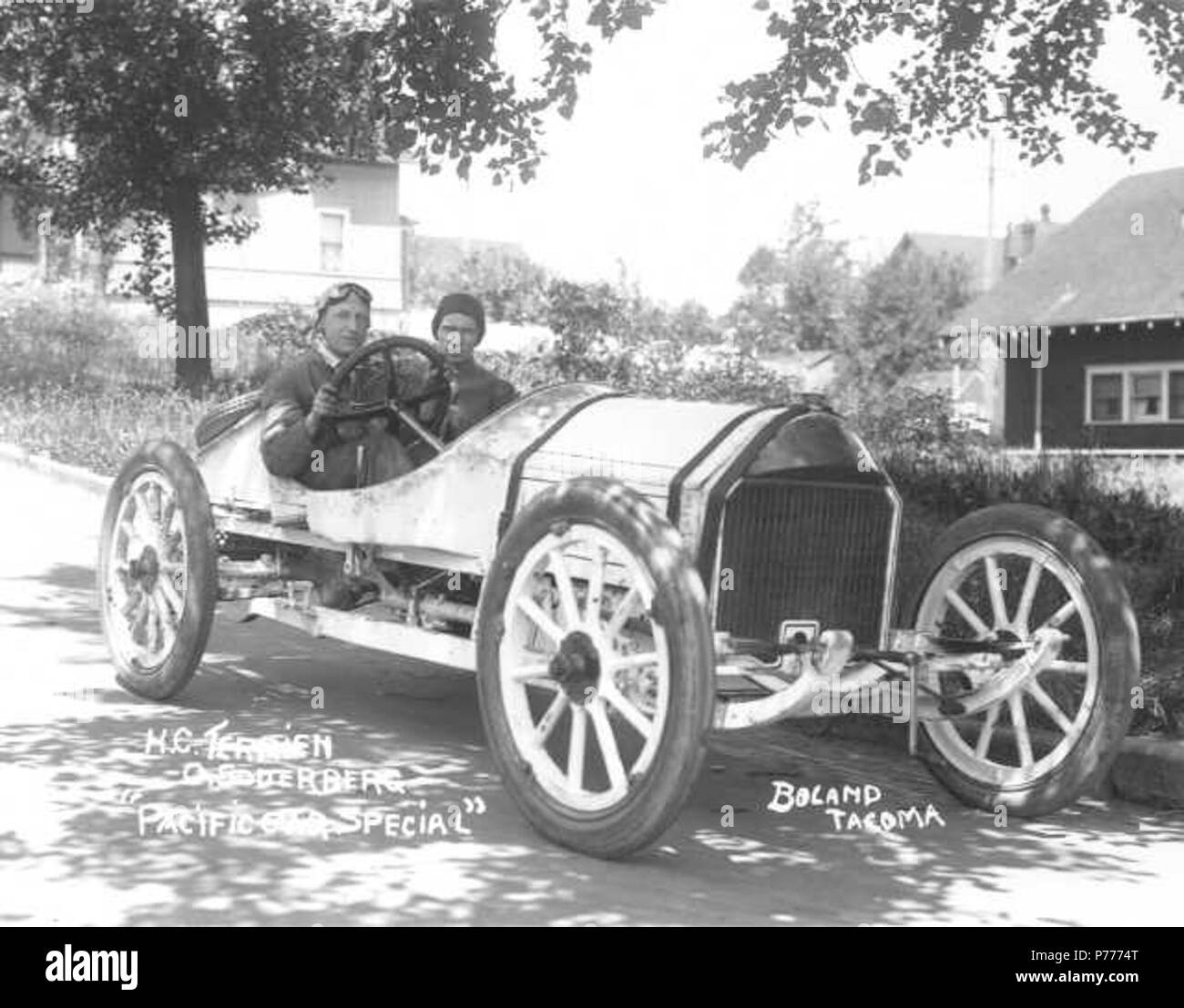 English: Herman C. Terrien of Tacoma sits behind the wheel of his small Regal along with his 'mechanician' Oscar Soderberg as the duo prepares for their entry in the InterCity 100-mile race scheduled for July 3, 1914 at the Tacoma Speedway. The car, dubbed the 'Pacific Car Special,' was altered at the Pacific Car Co., hence its name. As with racing cars of the time, the tires and steering wheel seem exceptionally large. The 'Pacific Car Special' was one of twelve cars entered in the first race of the 1914 Montamara Festo which was restricted to cars from the Pacific Northwest. The InterCity ra Stock Photo