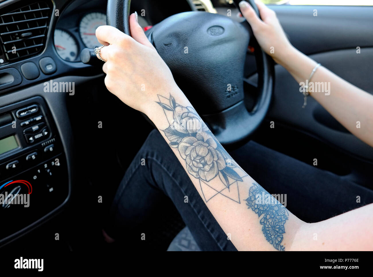 teenage female driver with tattoo on arm, norfolk, england Stock Photo
