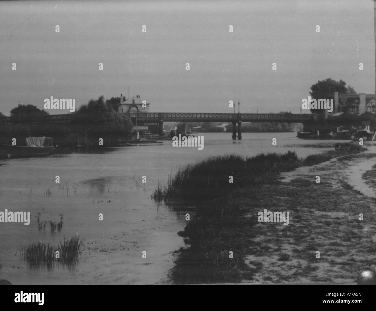 English: Caversham Bridge, Reading, from upstream, c. 1900. The waterman's house appears behind the bridge, and there is a large advertising sign for Salter's boats on the island. Bona's Caversham Bridge Hotel is to the right, with several steam launches moored by it. 1900-1909 : glass negative by H. W. Taunt, [numbered 8818], Box 21, un-numbered 3. 1900 15 Caversham Bridge, c. 1900 Stock Photo