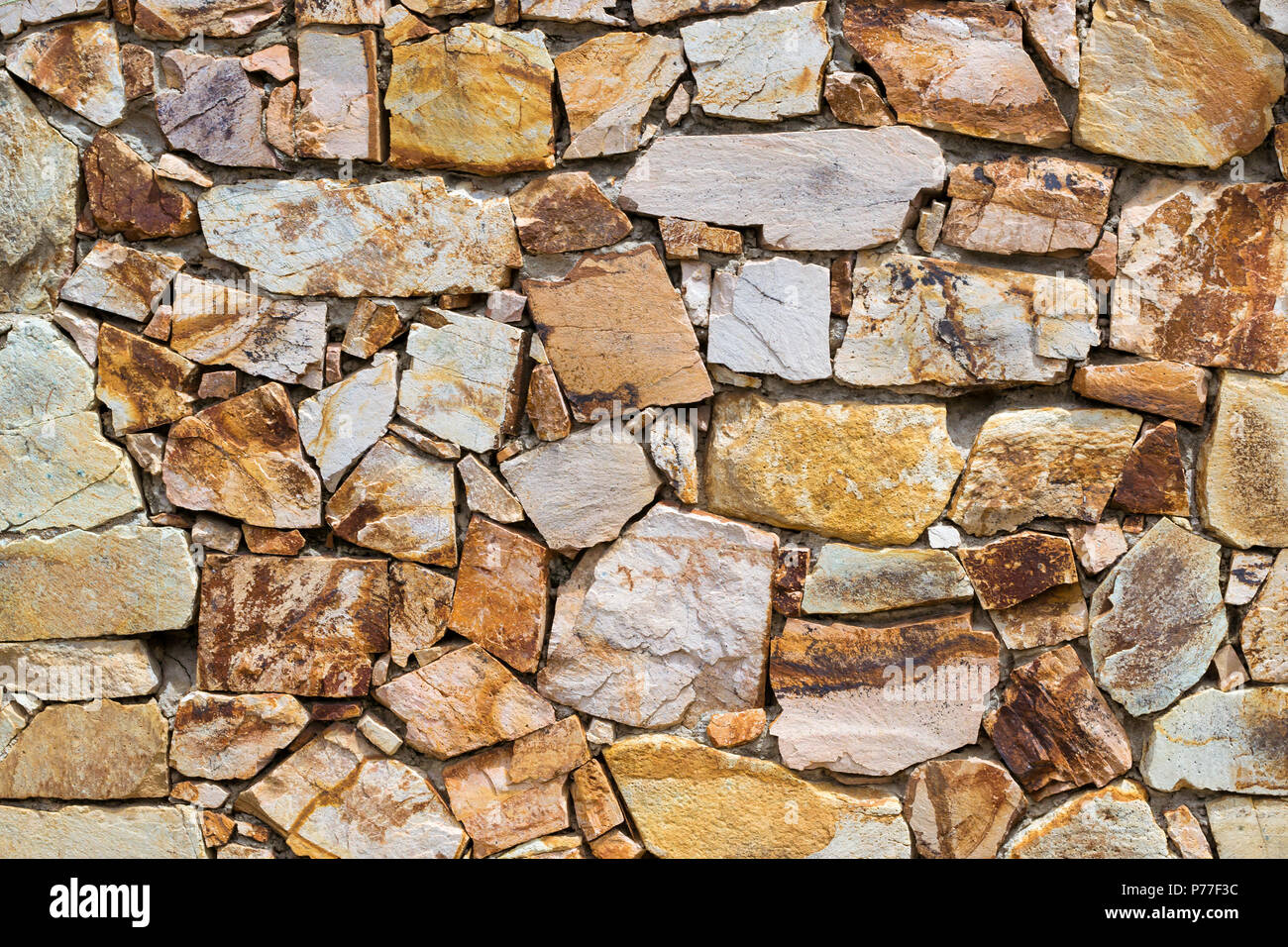 Decorative stone wall, pieces of rock bonded with cement. Cobble texture  with cracks. Mountain of castle San Juan. Spanish beach resort Blanes in  summ Stock Photo - Alamy