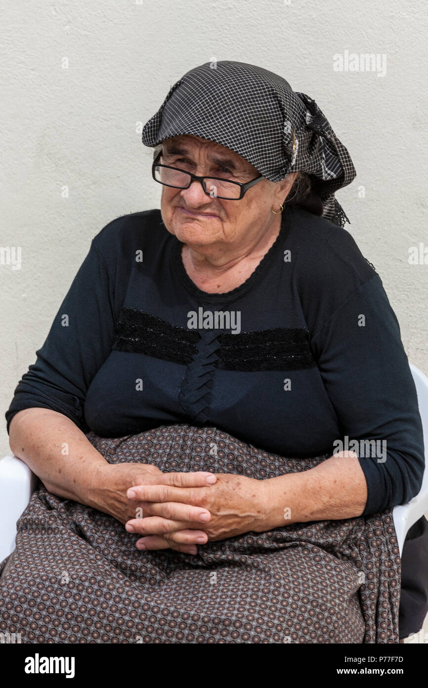 Old lady sits in the central square called Trg Svetog Stjepana outside the cathedral, Hvar, Split-Dalmatia, Croatia. Stock Photo