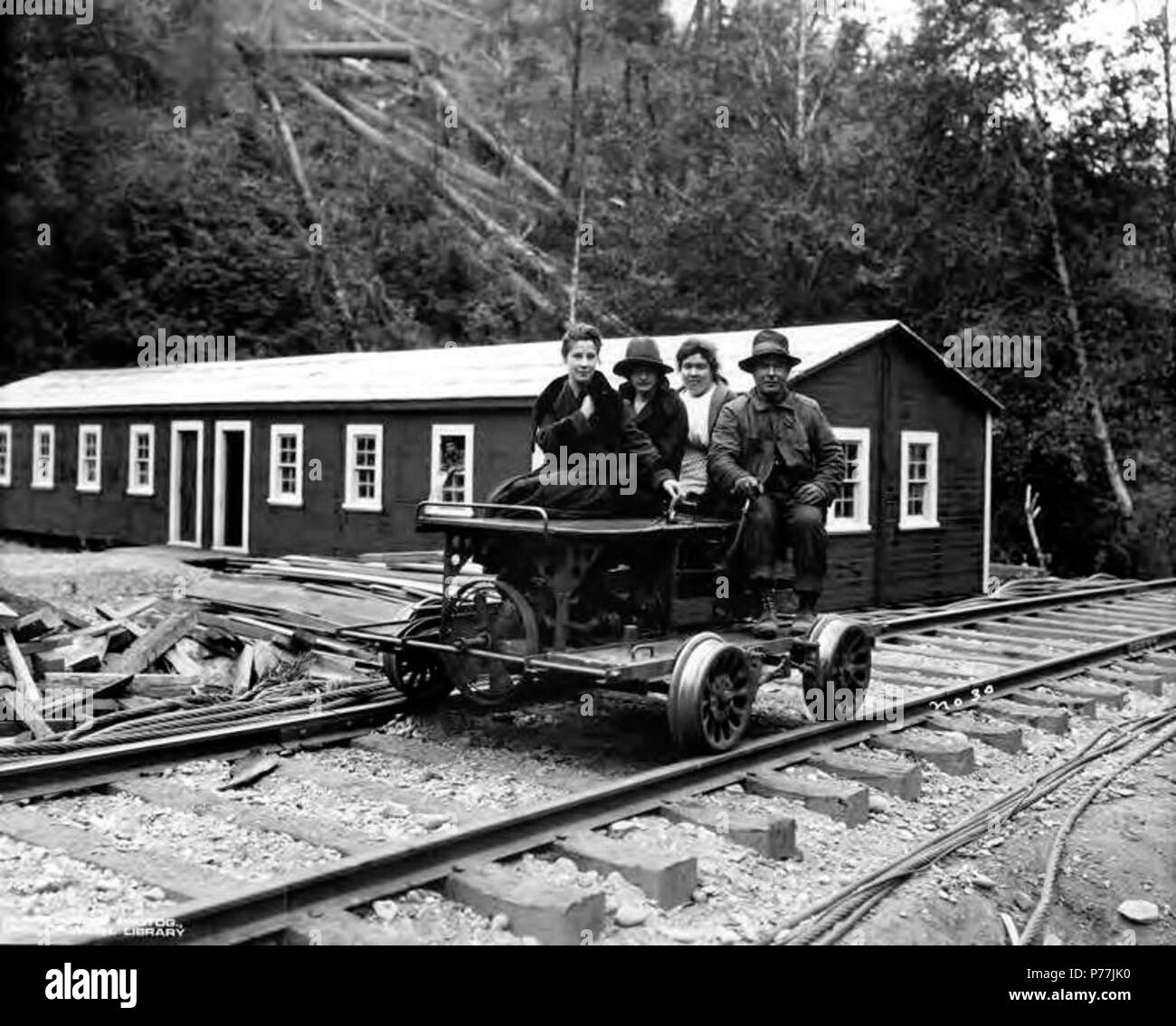 . English: Speeder with three women and one man in front of bunkhouse, Brighton Mills Company, Brighton, ca. 1922 . English: Caption on image: No. 31 PH Coll 516.240 Brighton was founded in 1910 and was named after the seaside resort in England. The Brighton Mills Company was founded in 1911 by the Watts Brothers of Bay City. The mill was closed in 1926. Subjects (LCSH): xyz  . circa 1922 12 Speeder with three women and one man in front of bunkhouse, Brighton Mills Company, Brighton, ca 1922 (KINSEY 2146) Stock Photo