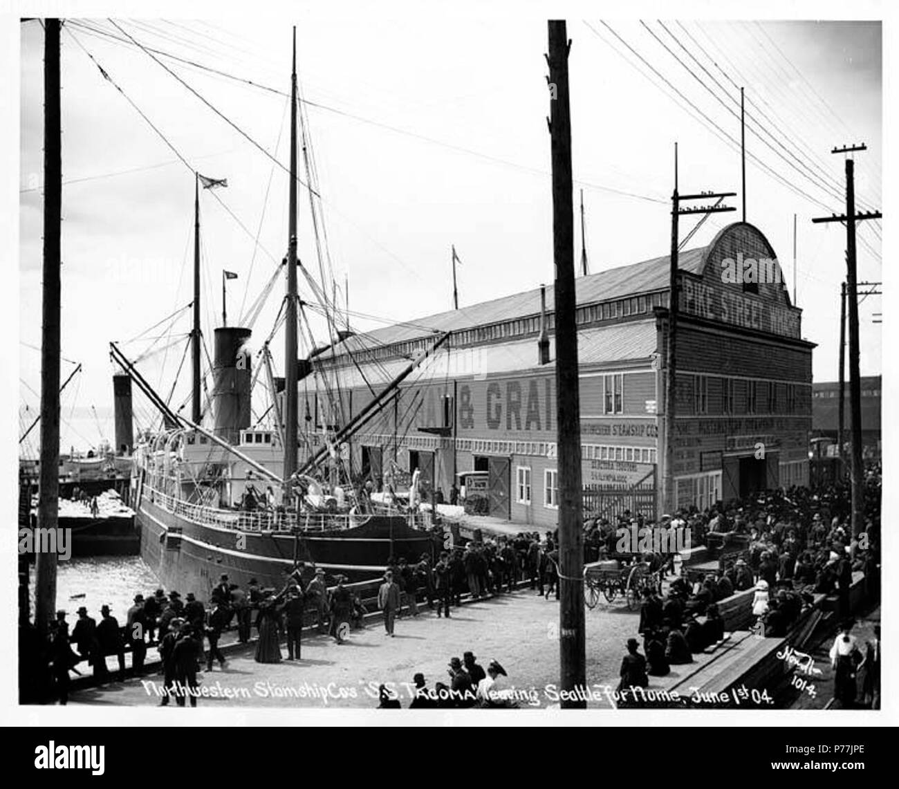 . English: Steamship TACOMA departing for Nome, Pike Street Wharf, Seattle, 1904 . English: Caption on image: Northwestern Steamship Co's 'S.S. Tacoma' leaving Seattle for Nome, June 1st 04. Nowell 1014 Subjects (LCTGM): Ships--Washington (State)--Seattle; Piers & wharves--Washington (State)--Seattle Subjects (LCSH): Tacoma (Ship); Pike Street Wharf (Seattle, Wash.) This pier shed, Pier 8 / Pike Street Wharf / Pike Street Pier, built 1896, was replaced in 1905 by the current structure known since the 1940s as Pier 59, now housing the Seattle Aquarium. (HistoryLink gives a somewhat different se Stock Photo