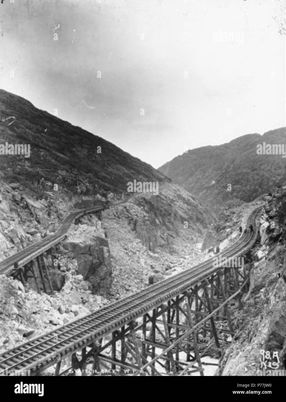 . English: Switchback on the White Pass and Yukon Railroad, Alaska, ca. 1899. English: Caption on image: 'Switch Back W.P. & Y.R.R.' Original image in Hegg Album 3, page 35 . Original photograph by Eric A. Hegg B286; copied by Webster and Stevens 98.A. Subjects (LCTGM): Railroad tracks--Alaska; Trestles--Alaska Subjects (LCSH): White Pass & Yukon Route (Firm)  . circa 1899 12 Switchback on the White Pass and Yukon Railroad, Alaska, ca 1899 (HEGG 490) Stock Photo