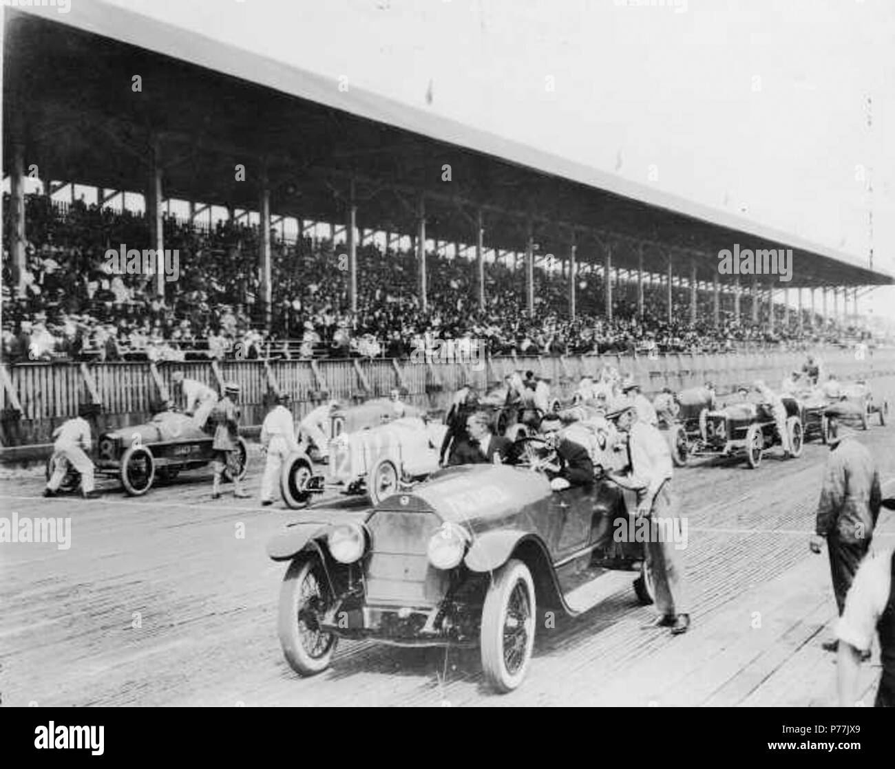 English: On July 4th 1922, thirty thousand fans crowded into the stands at the Tacoma Speedway to watch what turned out to be the last car race held at the Tacoma track. Ten drivers competed in the 250-mile race. The cars are lining up behind the pace car, driven by Barney Oldfield, prior to the checkered flag. Lined up are (l to r): front row- Tommy Milton #8 Leach Special, Harry Hartz #12 Duesenberg, Jimmy Murphy #35 Murphy Special; 2nd row- Joe Thomas #10 Duesenberg, Roscoe Sarles in the #31 Duesenberg, Cliff Durant in the #34 Durant Special; 3rd row- 'Howdy' Wilcox in the #16 Puegeot, Art  Stock Photo