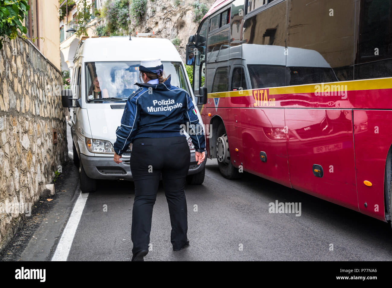 Positano, a cliffside village, Policewoman trying to sort out two vehicles stuck in the road because of the narrow road, Amalfi coast, Italy Stock Photo