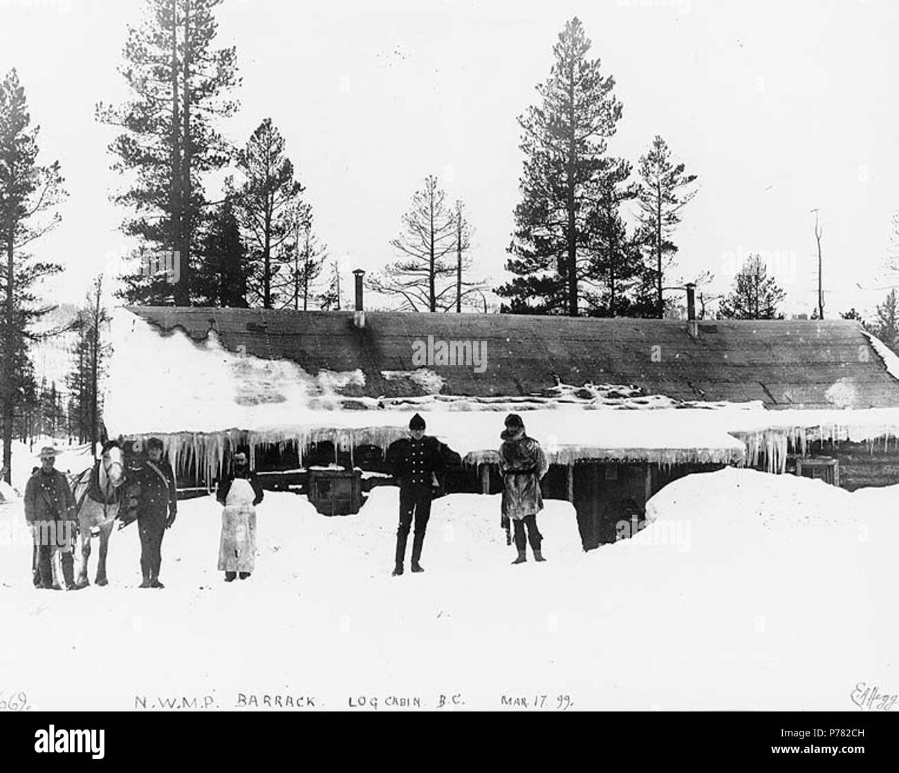 . English: North-West Mounted Police officers standing in front of barracks, Log Cabin, British Columbia, March 17, 1899. English: Caption on image: 'N.W.M.P. barrack. Log Cabin B.C. Mar 17 '99'' Original image in Hegg Album 2, page 40 . Klondike Gold Rush. Subjects (LCTGM): Mounted police--British Columbia--Log Cabin Subjects (LCSH): Canada. North West Mounted Police--Barracks and quarters  . 1899 10 North-West Mounted Police officers standing in front of barracks, Log Cabin, British Columbia, March 17, 1899 (HEGG 228) Stock Photo