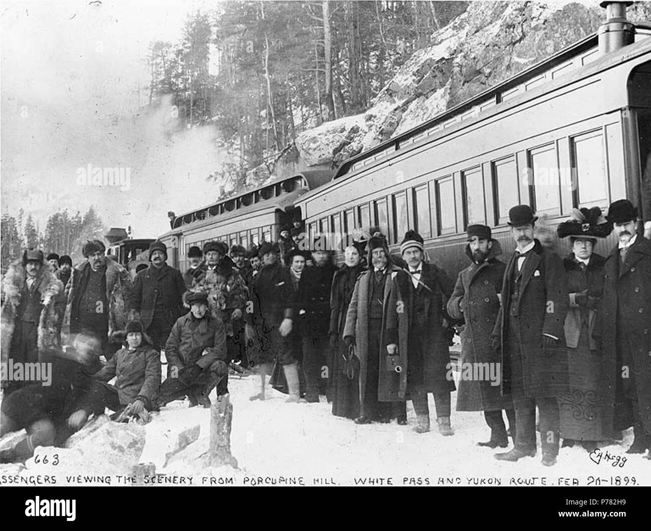 . English: Passengers disembarking from the White Pass & Yukon Railroad to view scenery from Porcupine Hill, Alaska, February 20, 1899. English: Caption on image: 'Passengers viewing scenery from Porcupine Hill. White Pass and Yukon Route. Feb 20 1899.' Original image in Hegg Album 2, page 36. Subjects (LCTGM): Railroads--Alaska--Porcupine Hill; Mountains--Alaska; Passengers--Alaska Subjects (LCSH): White Pass & Yukon Route (Firm); Porcupine Hill (Alaska); Portraits, Group--Alaska--Porcupine Hill  . 1899 10 Passengers disembarking from the White Pass &amp; Yukon Railroad to view scenery from P Stock Photo