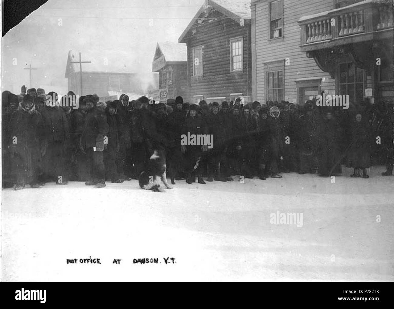 . English: Post Office at Dawson, Yukon Territory, ca. 1898. English: Shows long line of men outside of post office during winter . Caption on image: 'Post Office at Dawson Y.T.' Subjects (LCTGM): Post offices--Yukon--Dawson; Queues--Yukon--Dawson  . circa 1898 11 Post Office at Dawson, Yukon Territory, ca 1898 (HEGG 444) Stock Photo