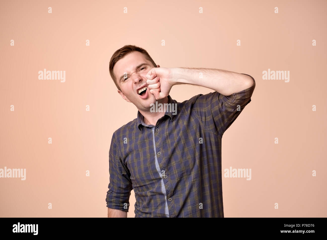 European man beating himself with fist in face. Stock Photo