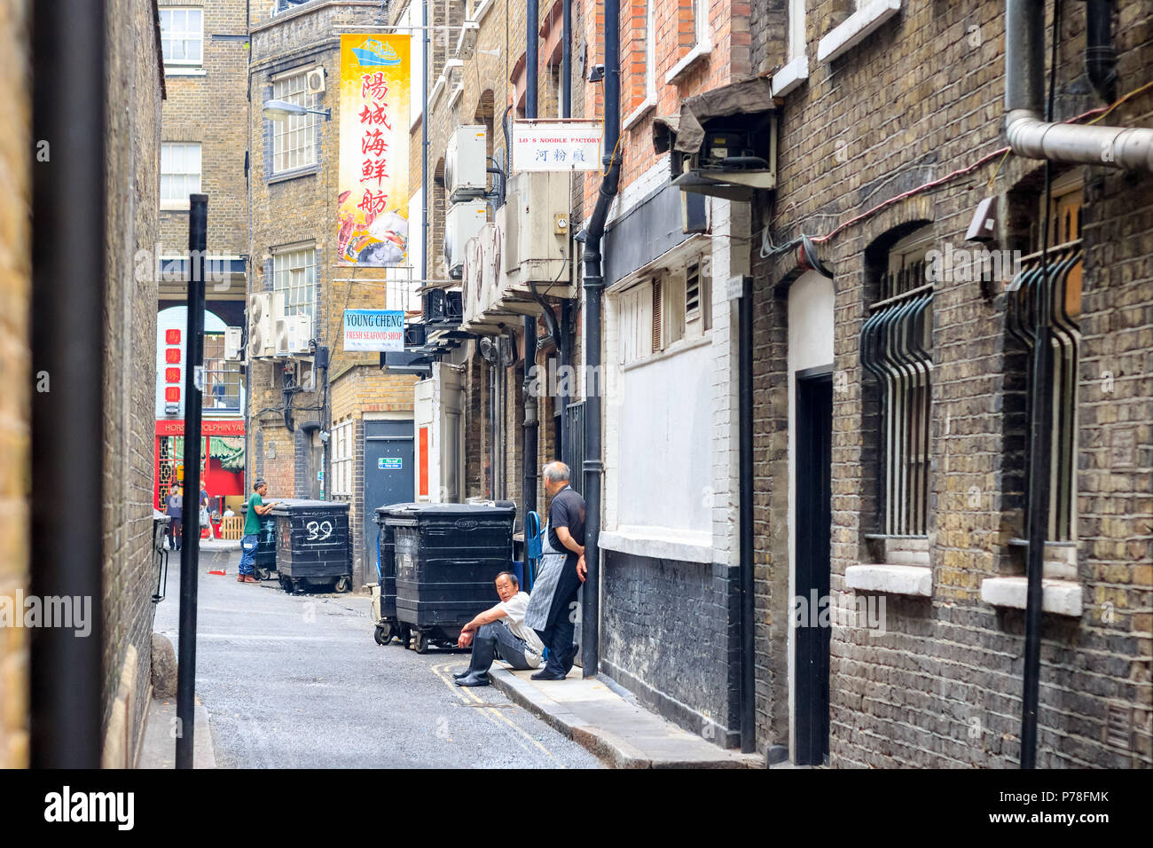 London, UK - June 22, 2018 - Restaurant staff having a break on the back street of London Chinatown Stock Photo