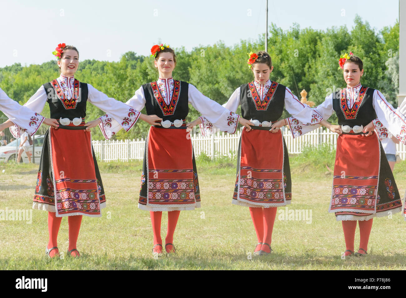 Kranevo, Bulgaria - June 10, 2018: People in authentic folklore costume in a meadow dancing Bulgarian traditional dance named Horo Stock Photo