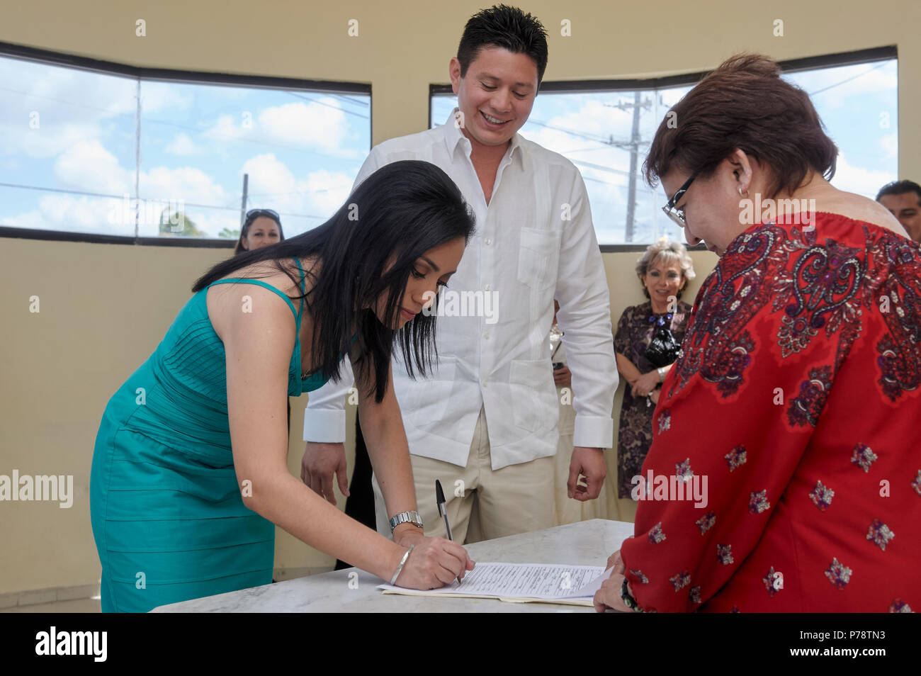 Young couple at their civil marriage ceremony, signing the marriage registry document. Stock Photo