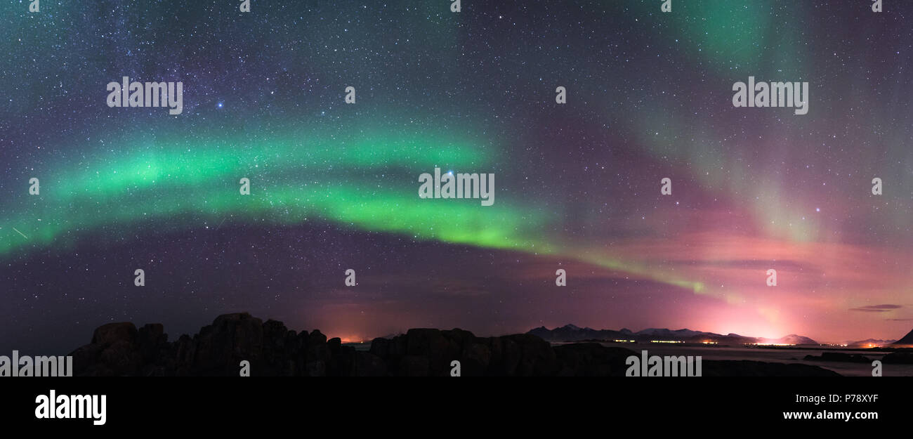 Aurora borealis above the mountains with milky way at Lofoten Norway