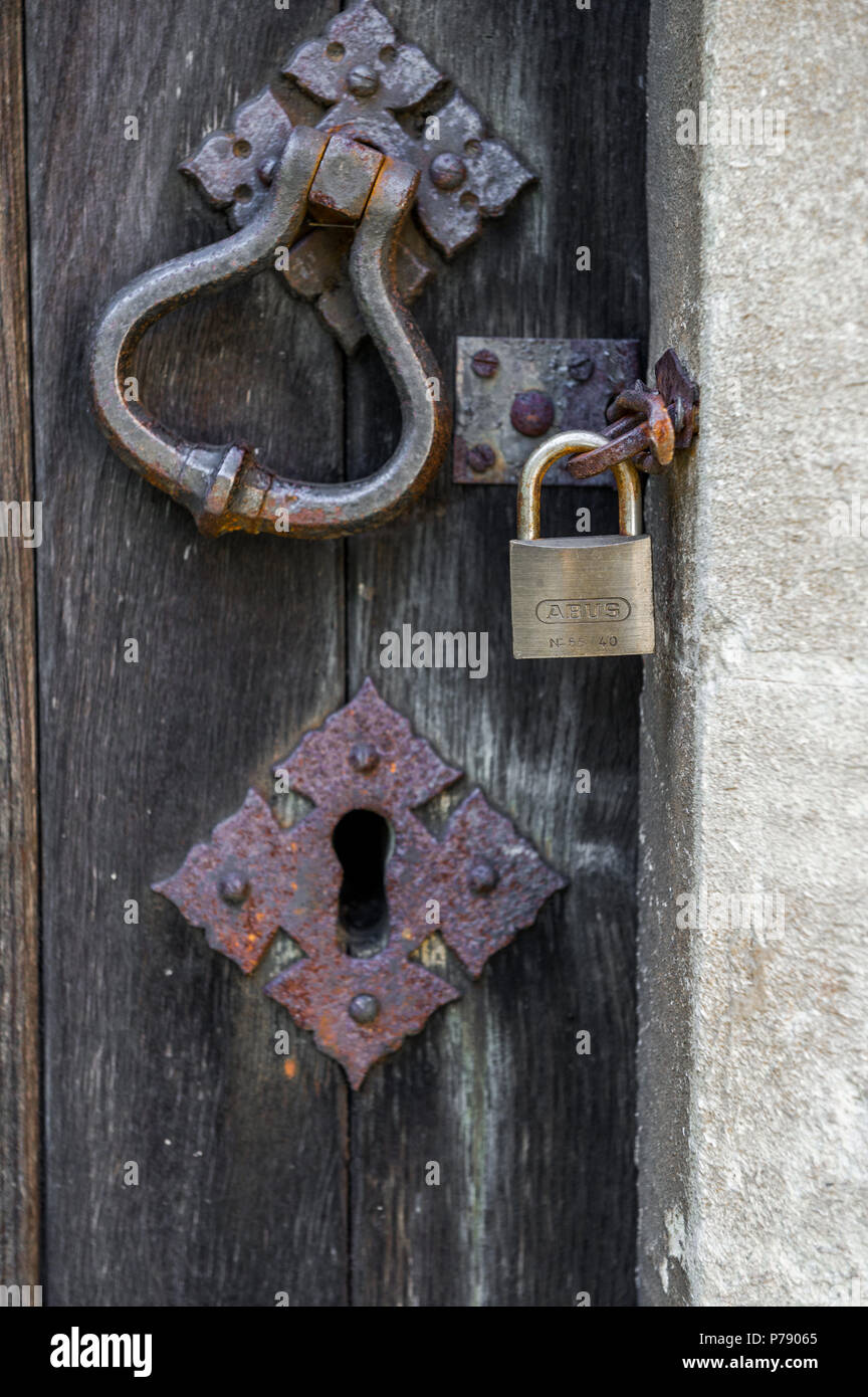 ABUS padlock locking a wooden door to a stone door frame. Stock Photo