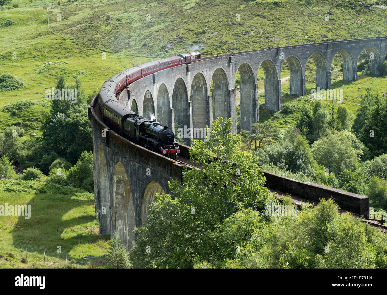 The Jacobite Express also known as the Hogwarts Express crosses the Glenfinnan Viaduct on route between Fort William and Mallaig. Stock Photo