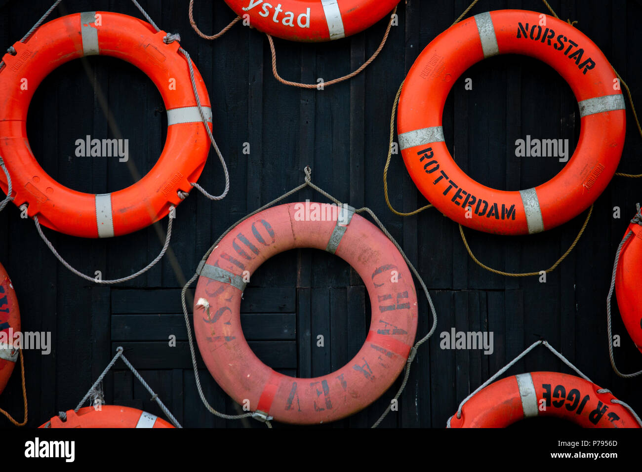 A collection of lifesavers on the side of the wall Stock Photo