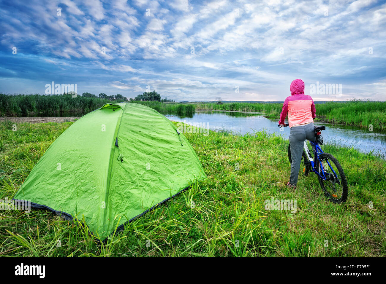 Girl with bicycle on the lake shore Stock Photo