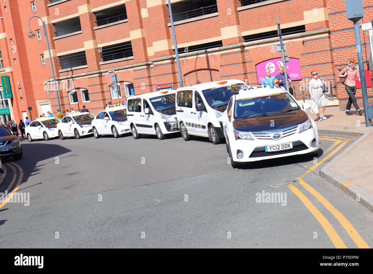 A line of taxi cabs wait to move down the line to pick up passengers outside Leeds Train Station