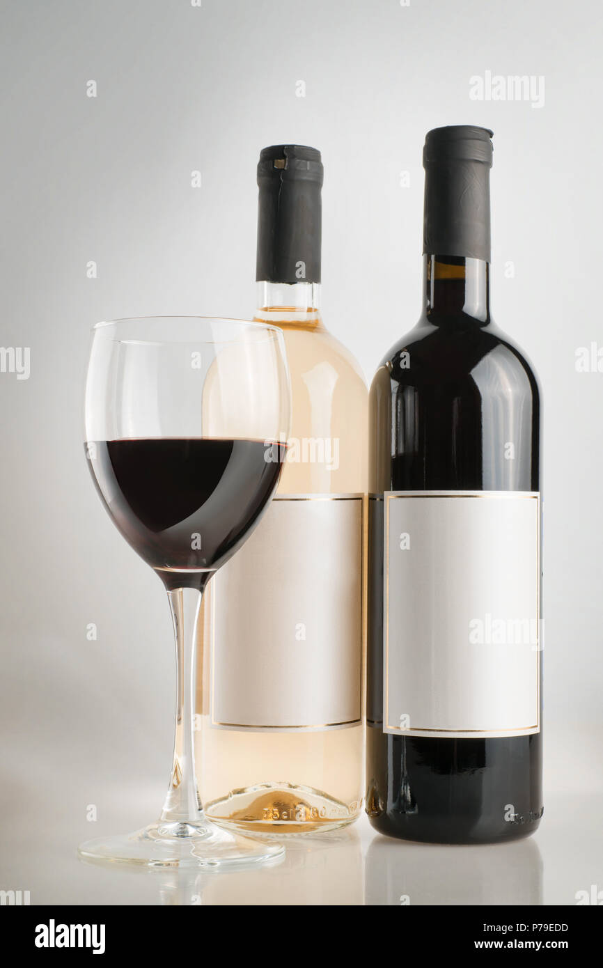Red and white wine bottles with blank labels and red wine glass. On ...
