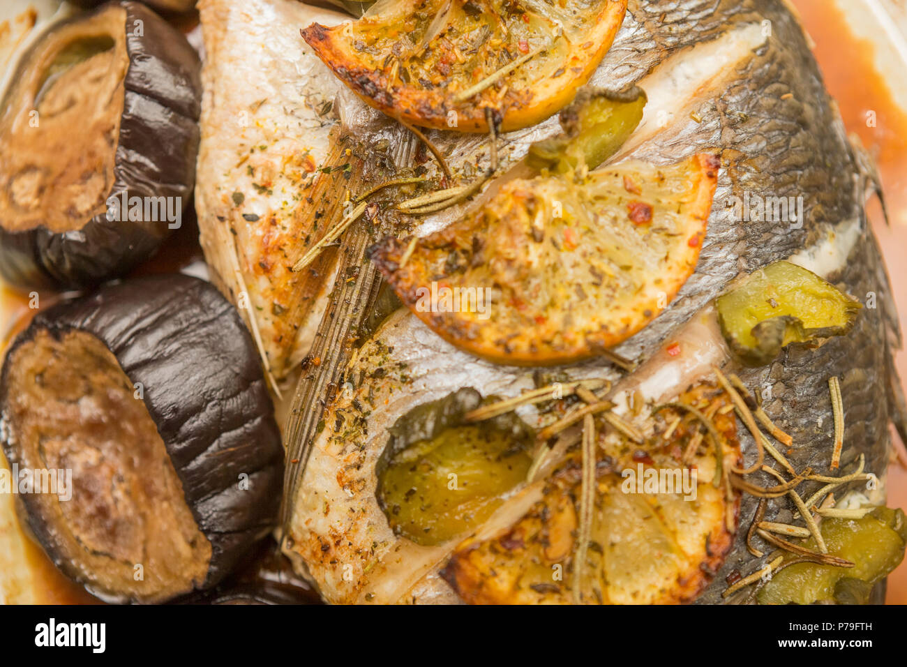 Baked dorado fish with lemon and eggplant. Stock Photo