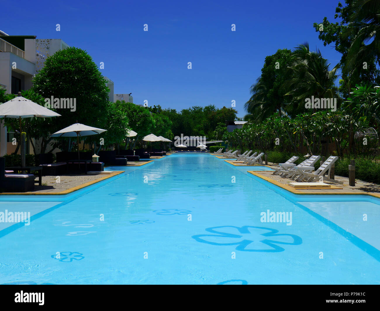 Beautiful swimming pool in hotel resort with umbrella and chair around. Stock Photo