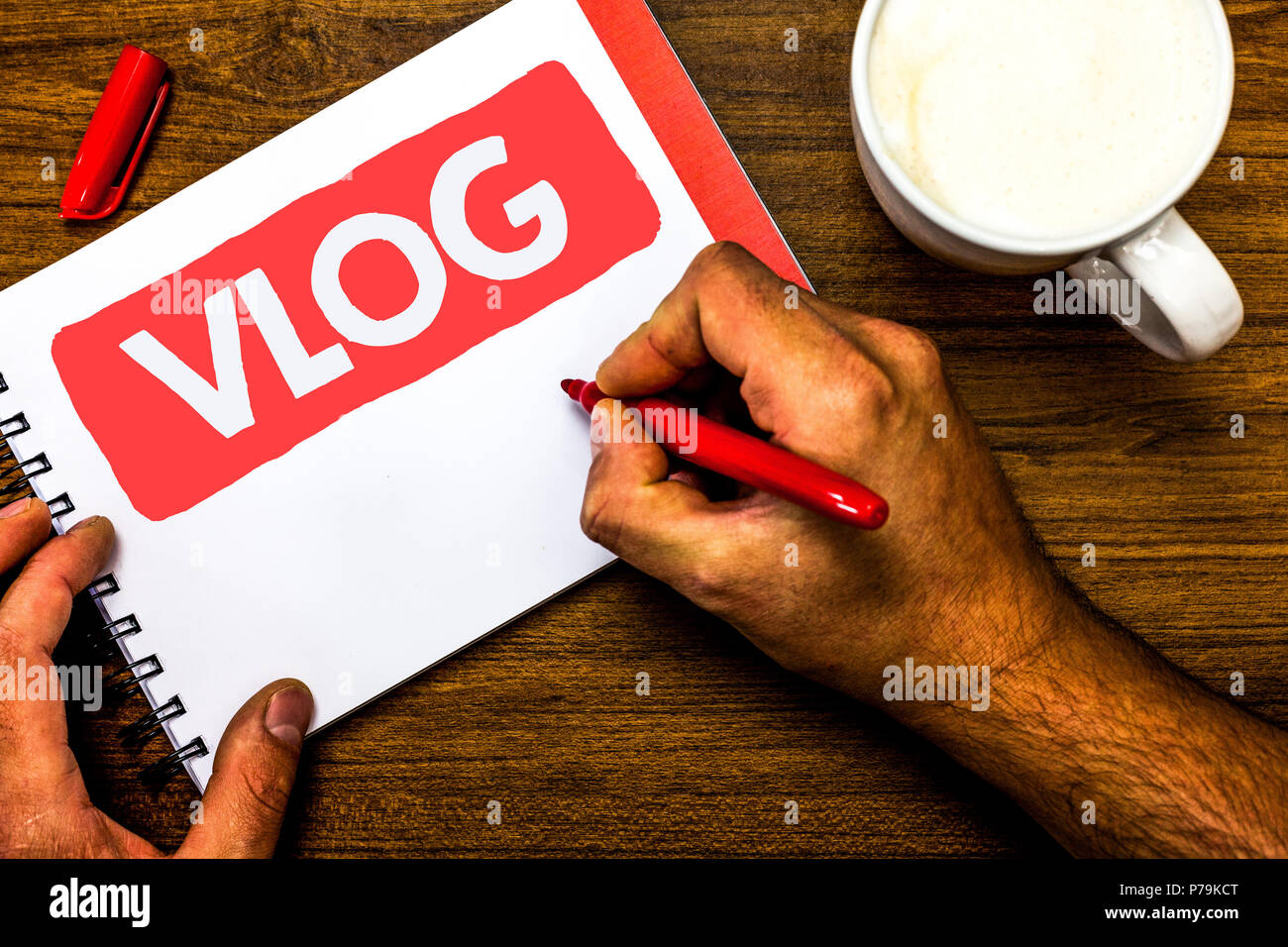 Text sign showing Vlog. Conceptual photo Entertaining multimedia self broadcasting news reporting stories Cup marker red pen notepad white paper nice  Stock Photo
