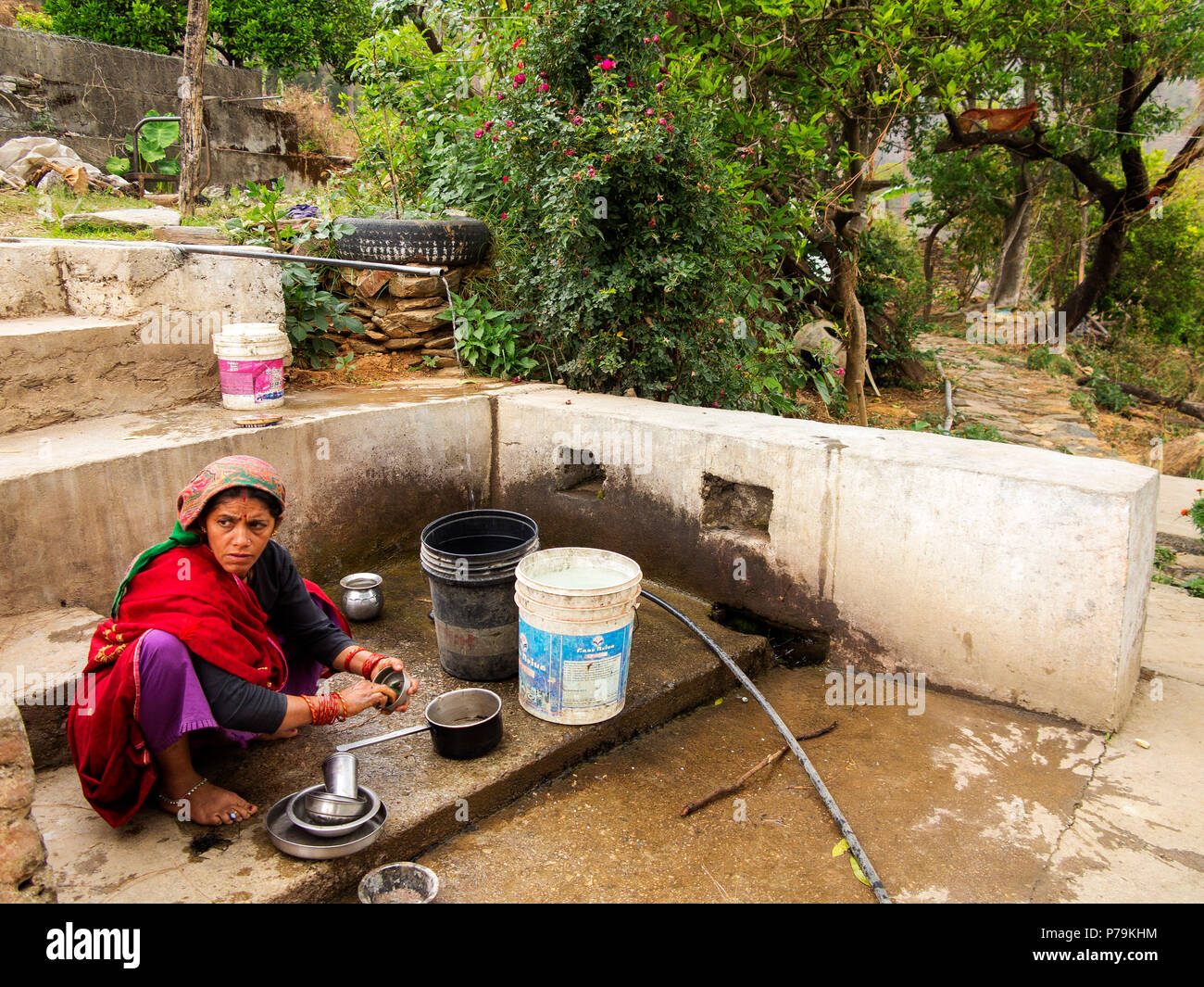 Indian woman washing dishes at Dalkanya Village, Nandhour Valley, Kumaon Hills, Uttarakhand, India Stock Photo