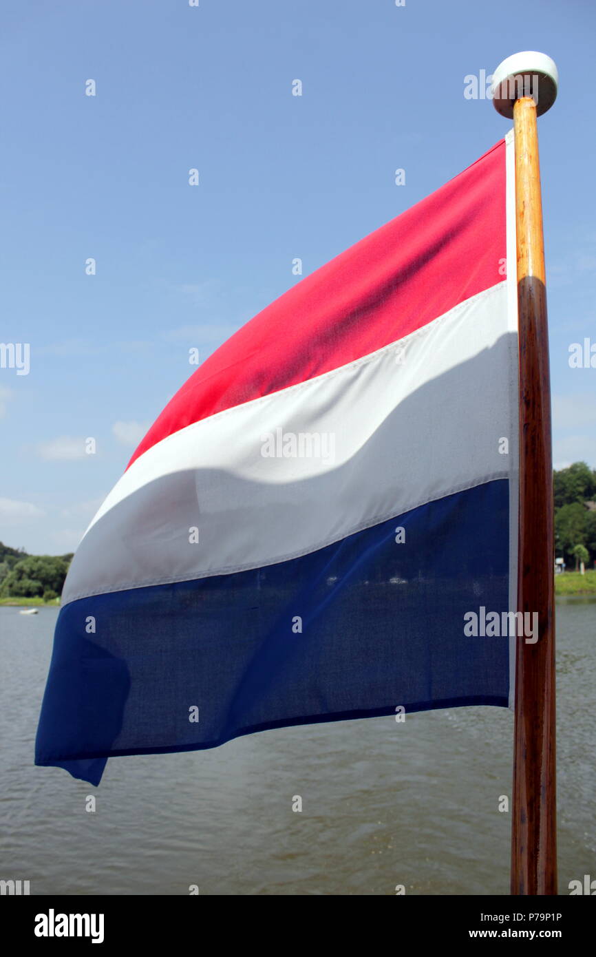 Dutch flag and flagpole. The flag is waving in the wind on a boat
