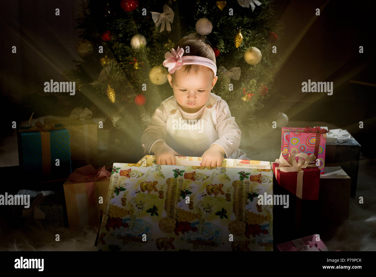 oneyearold little girl solemnize Christmas, sit under Christmastree