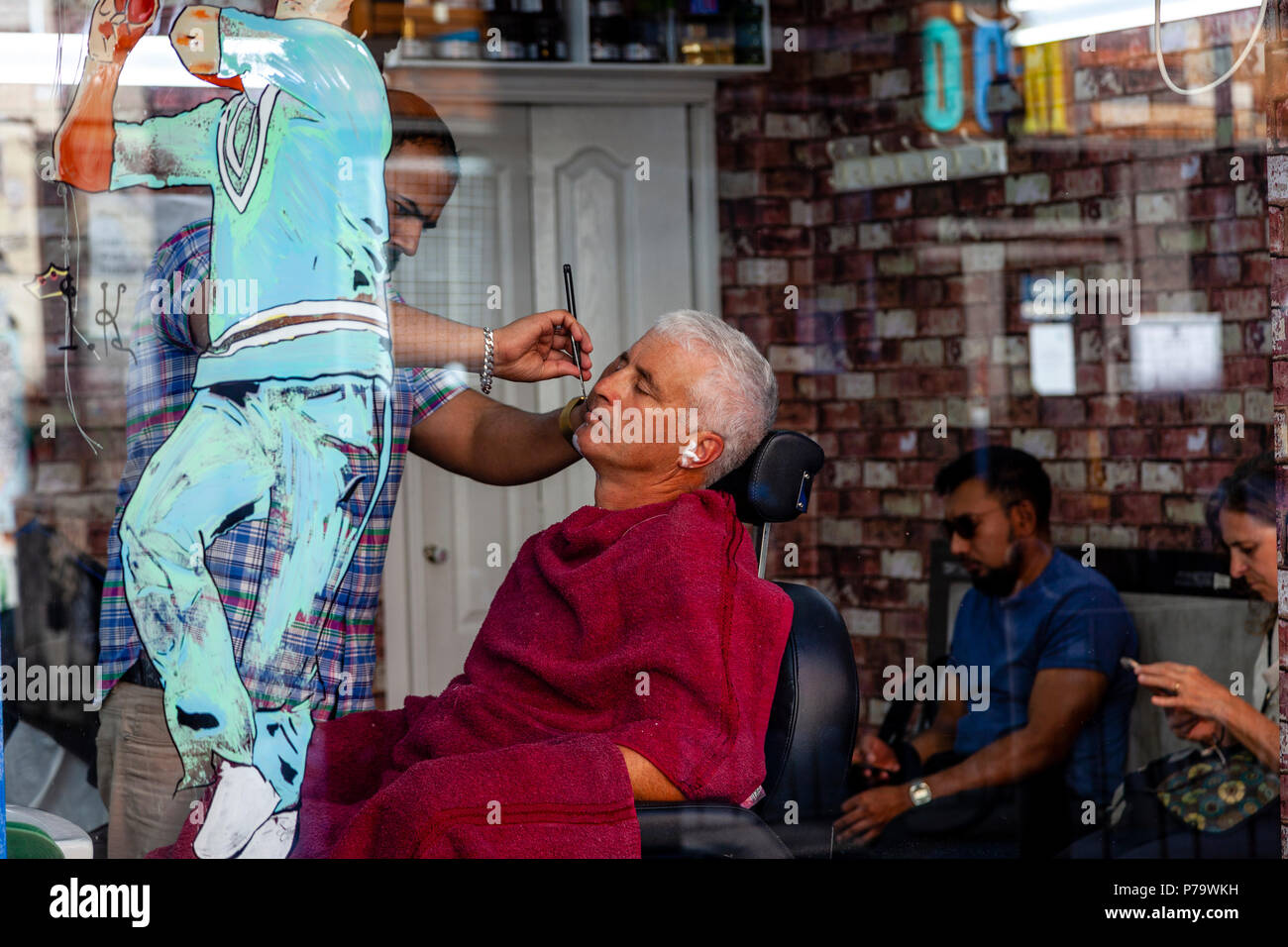 A Man Having A Wet Shave In A Hairdressing Salon, Brick Lane, London, United Kingdom Stock Photo