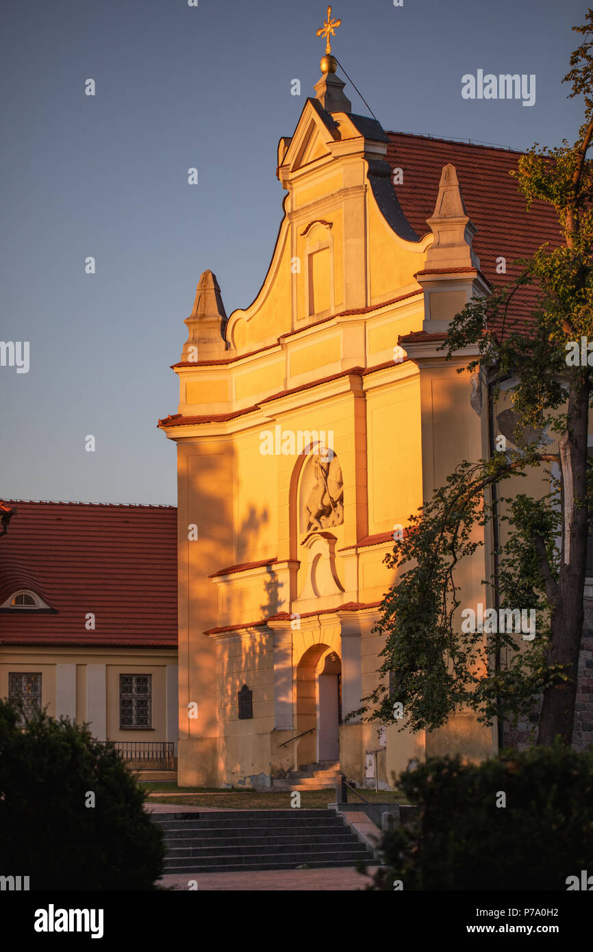 St George's Church in Gniezno, Poland. Old town sacred buildings, architecture of the first polish capital. Evening view, golden hour photo. Stock Photo