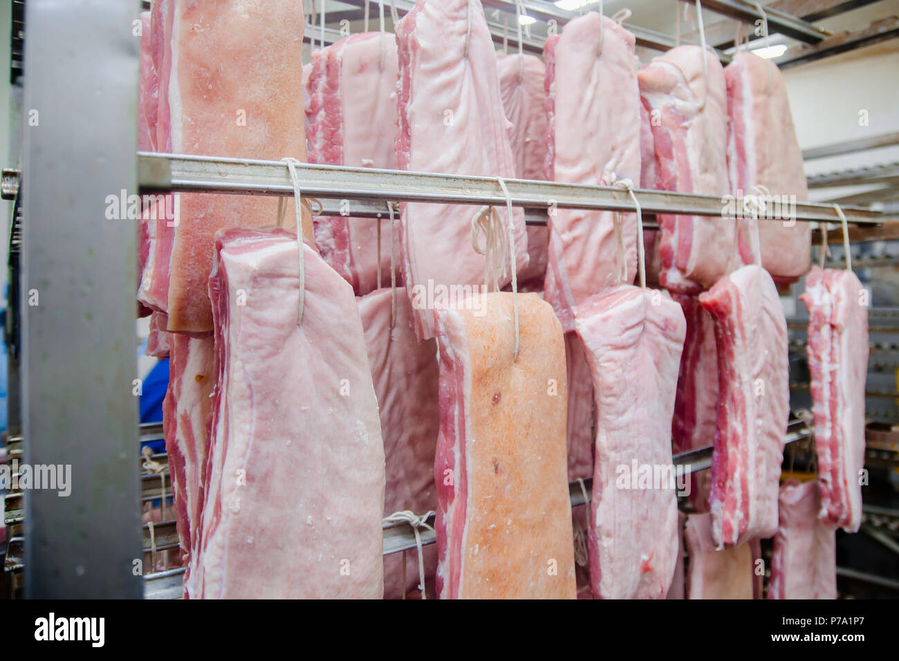 Pork. The line for the production of smoked delicacies. Industrial manufacture of sausage products. Smokehouse of meat products. Stock Photo