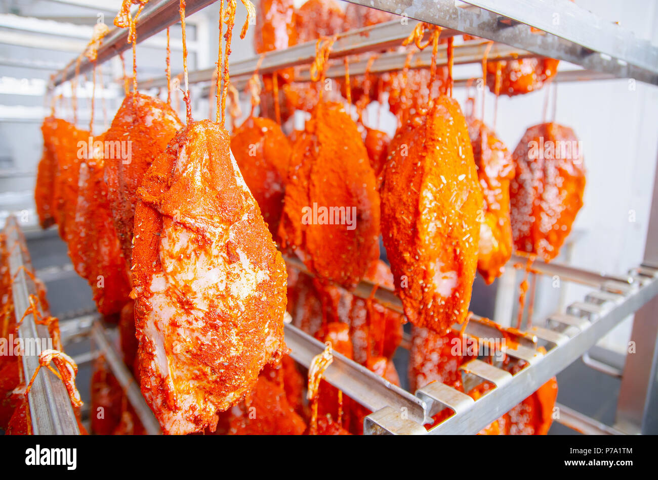 Pork. The line for the production of smoked delicacies. Industrial manufacture of sausage products. Smokehouse of meat products. Stock Photo