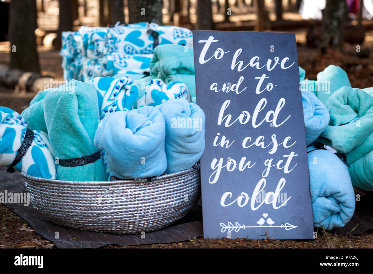 Blankets as wedding favors at a winter wedding ceremony in a forest