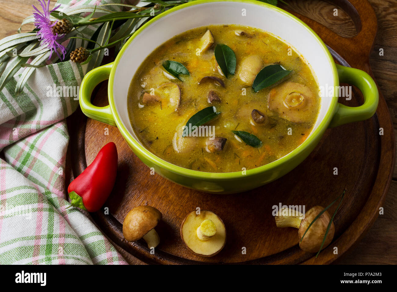 Mushroom vegetable soup in the green rustic bowl on the wooden table, close up. Vegetarian healthy food Stock Photo