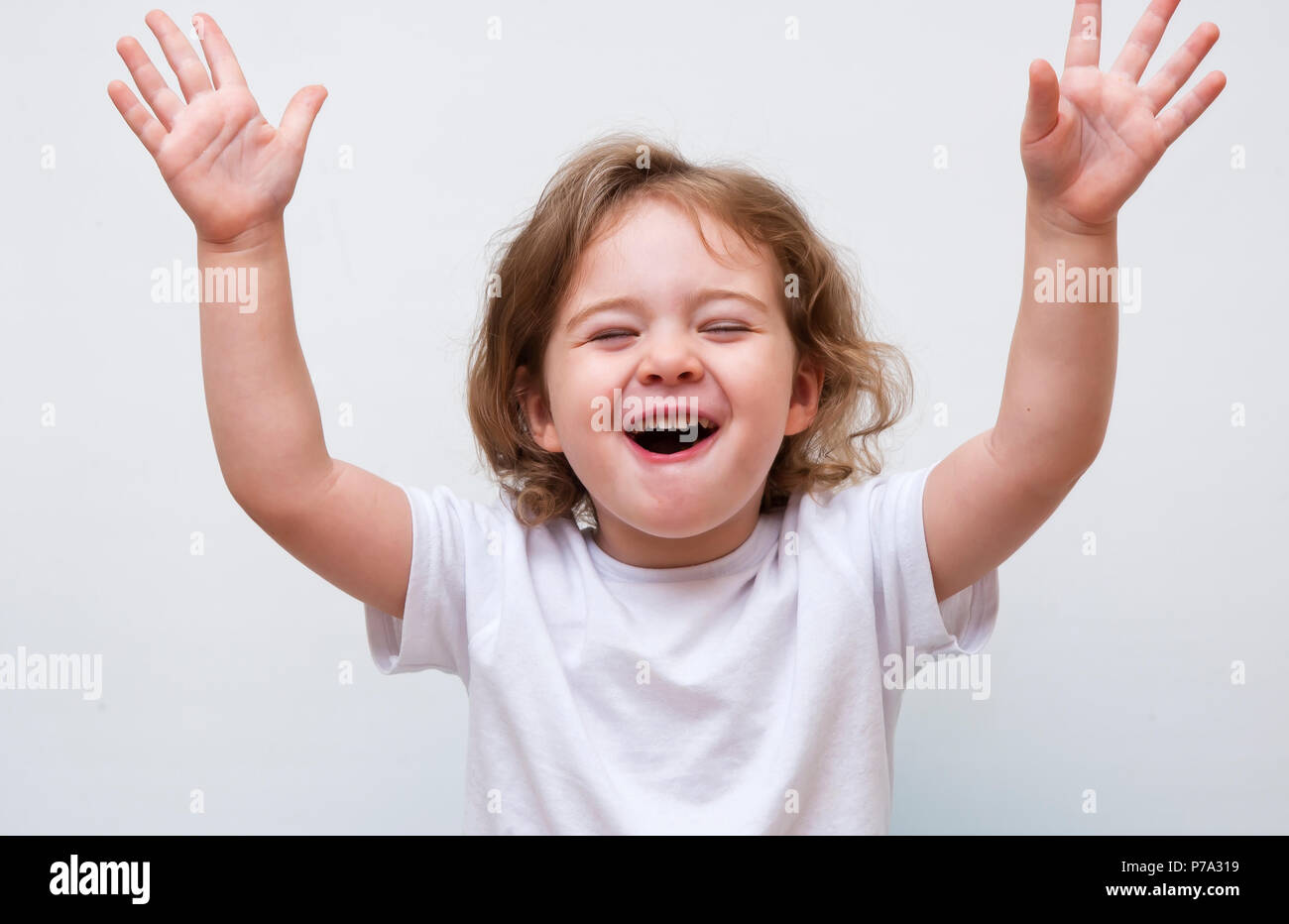 Young smiling girl holding hands up Stock Photo