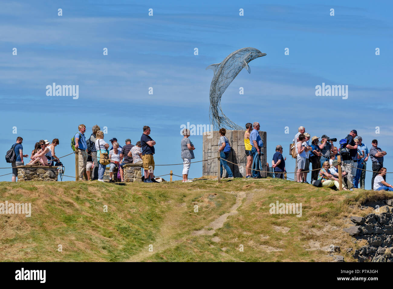 PORTSOY FESTIVAL ABERDEENSHIRE SCOTLAND PEOPLE GATHER AROUND THE DOLPHIN MONUMENT TO WATCH THE BOAT RACES Stock Photo