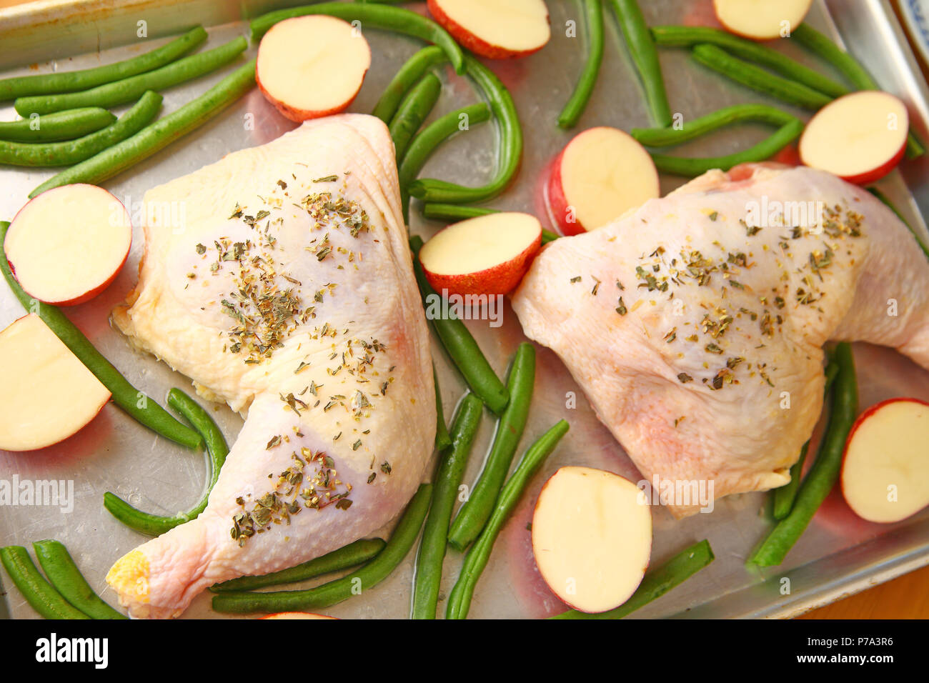 Sheet pan dinner of chicken, potatoes and green beans ready to go in the oven Stock Photo