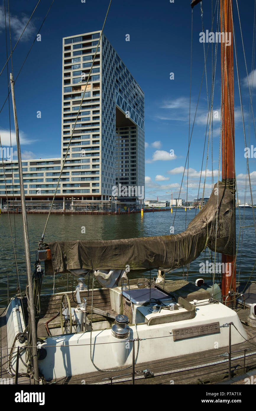 Delapidated sailing boat moored in front of the new Pontsteiger apartment complex, Amsterdam, The Netherlands. Stock Photo