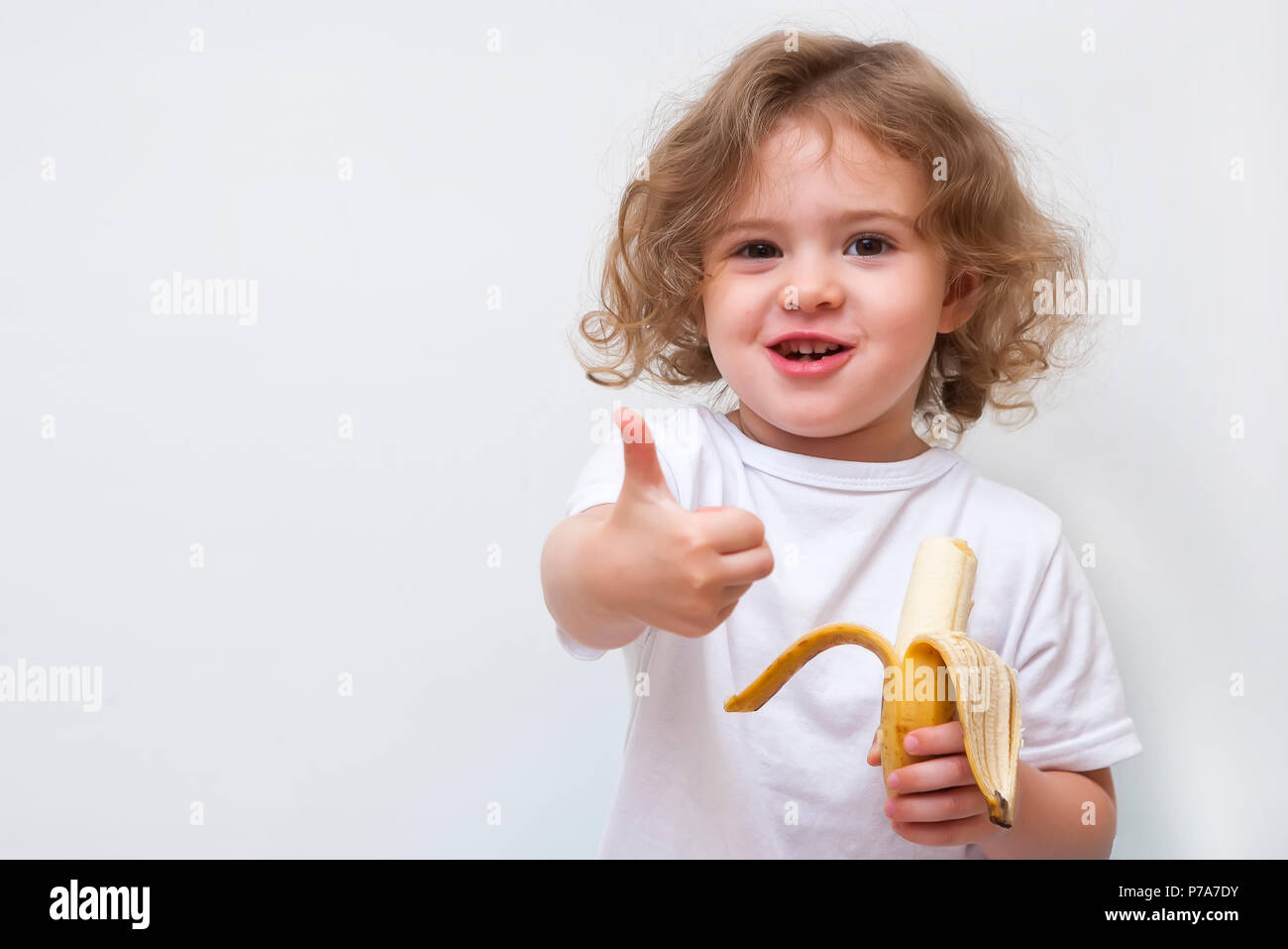 Little Girl Eating Banana High Resolution Stock Photography and Images