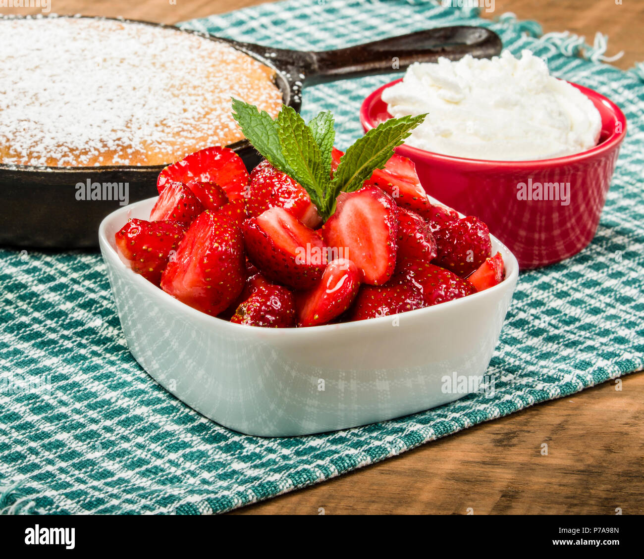 Bowl of fresh red strawberries with skillet cake Stock Photo