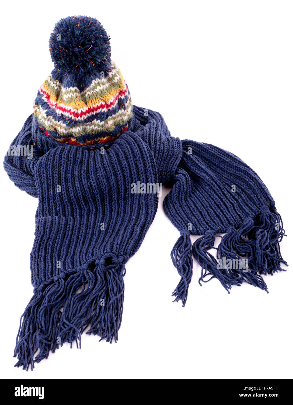 Blue winter bobble hat and matching scarf with tassels or fringe isolated against a white background Stock Photo