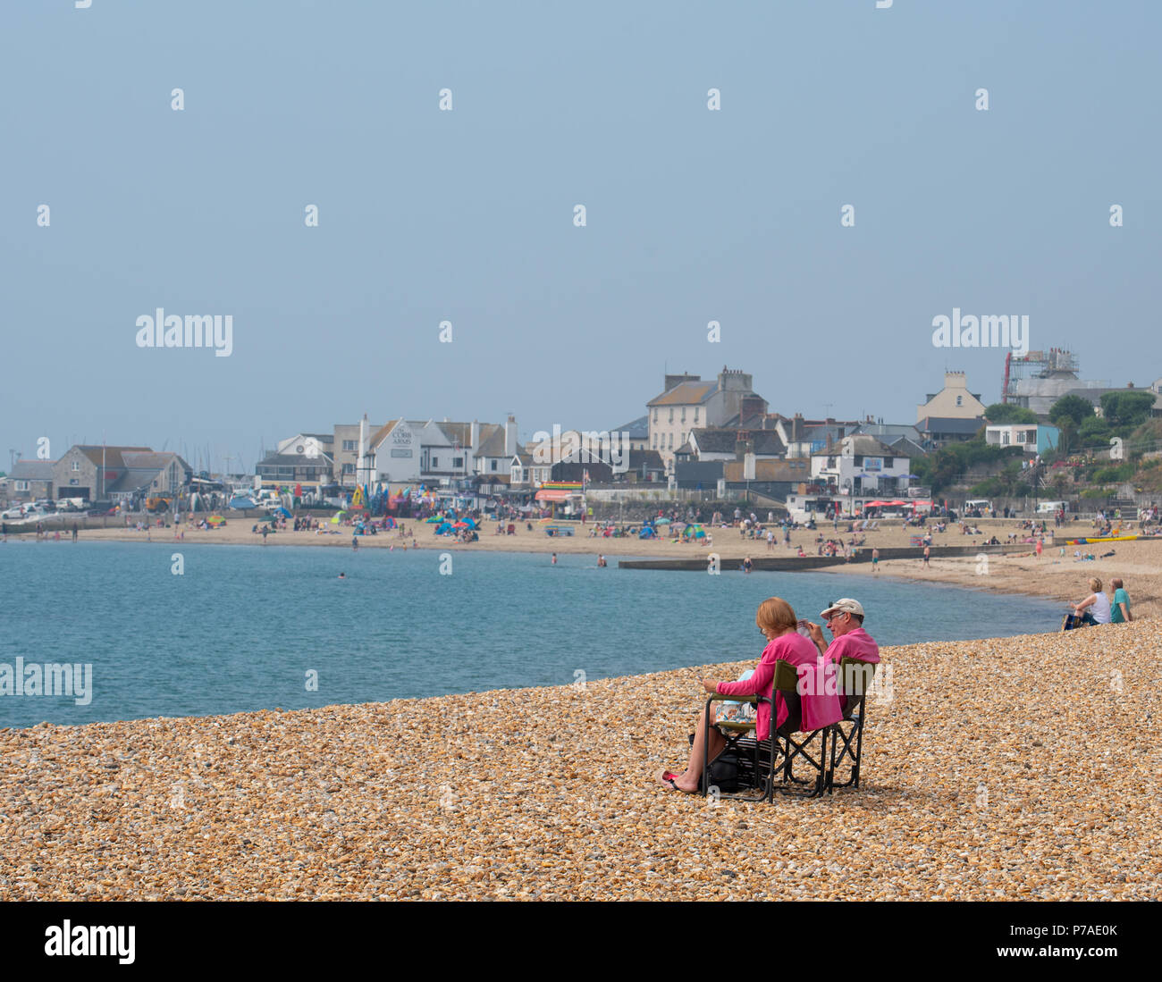 Lyme Regis, Dorset, UK. 5th July 2018. UK Weather: Hot with hazy sunshine in Lyme Regis. Visitors and locals head to the beach at the coastal resort of Lyme Regis. The outlook is good with high pressure dominant brigning hot conditions and humidity over the weekend. Credit: Celia McMahon/Alamy Live News Stock Photo