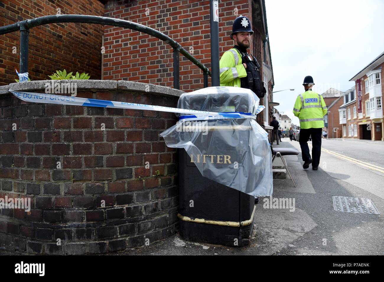 Amesbury, Wiltshire, UK. 5th July, 2018.A police officer stands at a cordoned off litter bin on Rollestone Street, Salisbury Credit: Finnbarr Webster/Alamy Live News Stock Photo